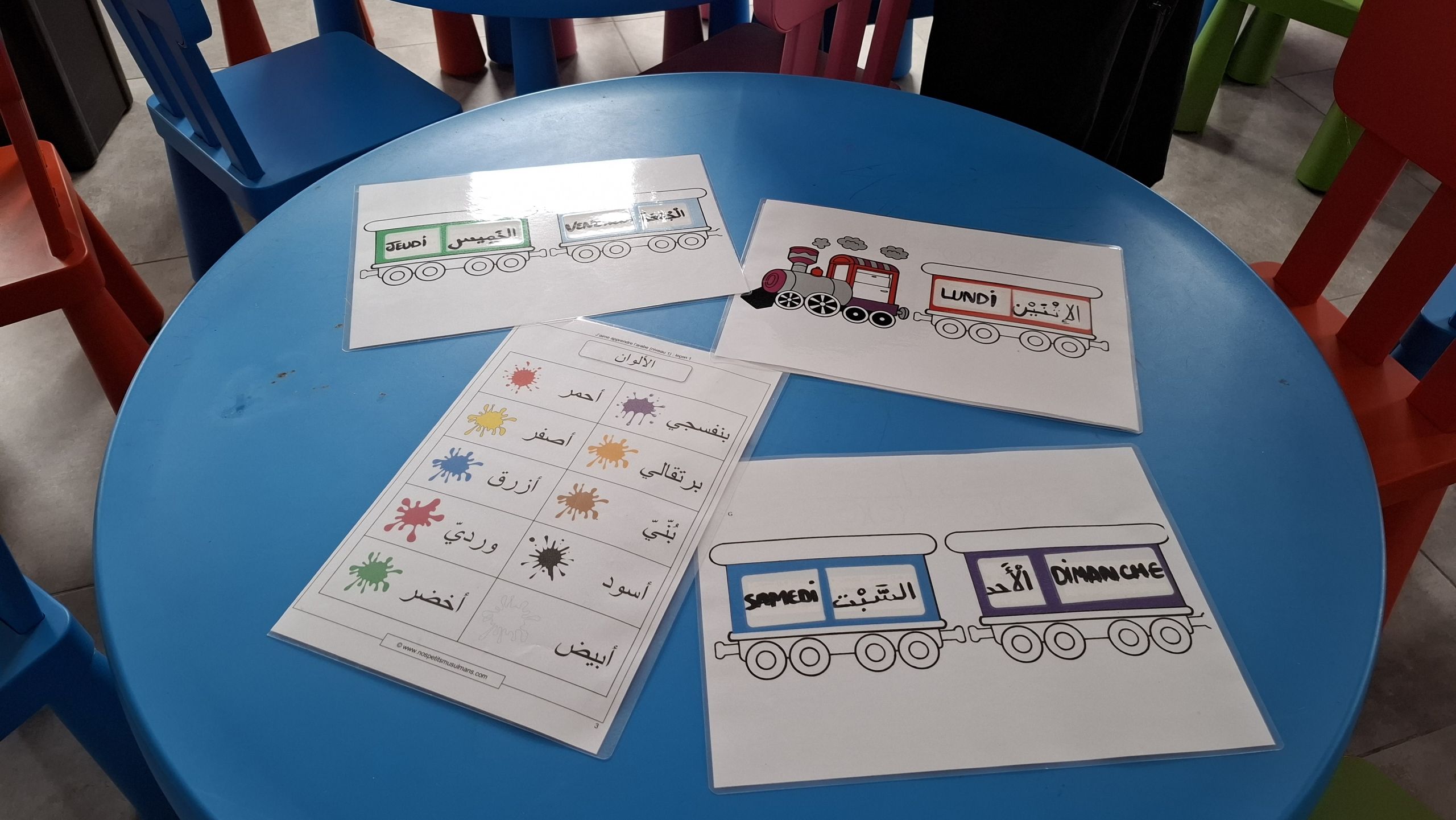 Livres et exercices d'apprentissage du Coran et de l'alphabet arabe posés sur une table
