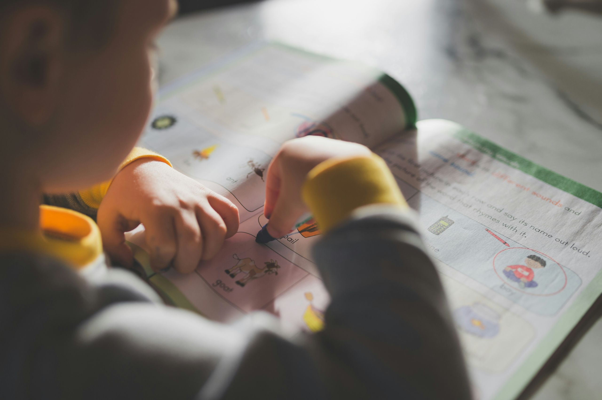 Enfant qui est entrain de travailler ses cours devant un cahier Enfant qui est entrain de travailler ses cours devant un cahier